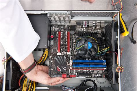 Asmuo, diegiantis tinklo plokštę į kompiuterio pagrindinę plokštę